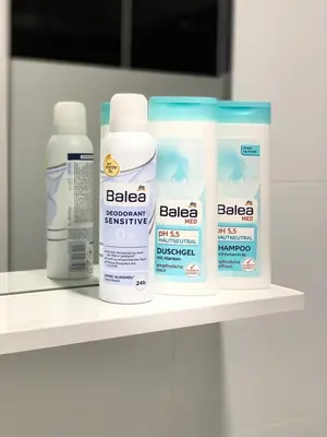 a shelf with four bottles of bathroom products on it at Apartmani GO Bugojno in Bugojno