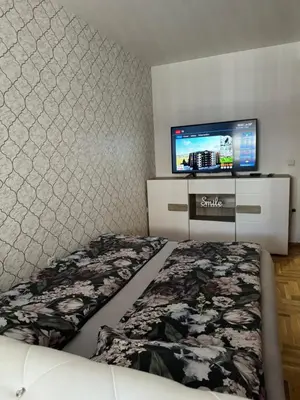 a bedroom with a bed and a flat screen tv at Apartman CITY CENTER 1-šetalište in Prijedor