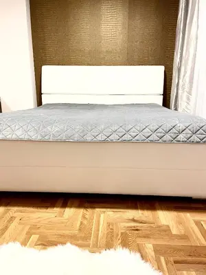 a white bed in a bedroom with a wooden floor at Apartman CITY CENTER 1-šetalište in Prijedor