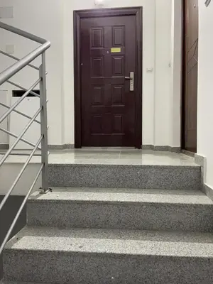 a brown door on a white building with stairs at Apartman CITY CENTER 1-šetalište in Prijedor
