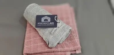 a tag sitting on top of a pink towel at Apartments Jack in Bihać