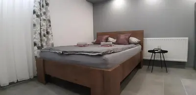 a bedroom with a bed with a wooden headboard at Apartments Jack in Bihać