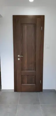a wooden door in a room with a tile floor at Apartments Jack in Bihać