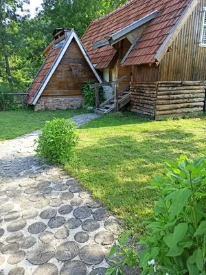 a log cabin with a stone path in front of it at BUNGALOV COZY UNA in Kulen Vakuf