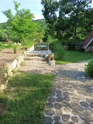 a stone path with a picnic table in a yard at BUNGALOV COZY UNA in Kulen Vakuf
