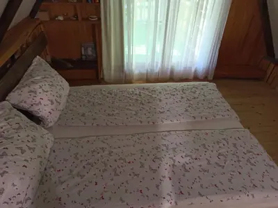 an unmade bed in a bedroom with a window at BUNGALOV COZY UNA in Kulen Vakuf