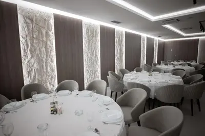 a room filled with tables and chairs with white tablecloths at Hotel IN in Žepče