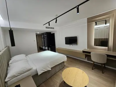 a bedroom with a bed and a desk and a television at Hotel IN in Žepče