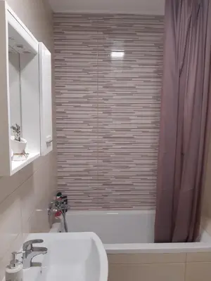a bathroom with a shower with a sink and a tub at Elena apartmani in Tuzla