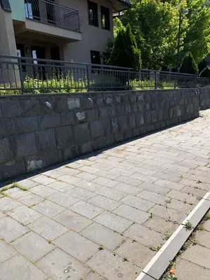 a brick sidewalk next to a stone retaining wall at Apartment Nice View in Fojnica