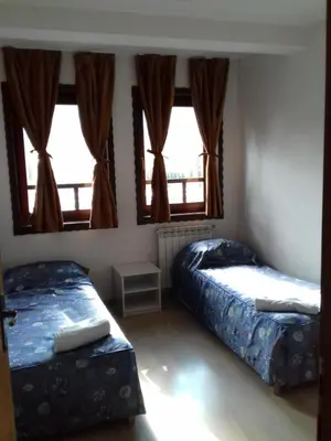 two beds in a room with two windows at Apartment Nice View in Fojnica