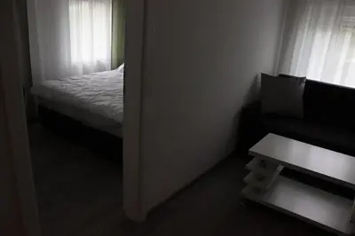 a small bedroom with a bed and a window at DMApartmani in Tuzla