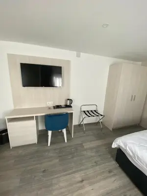 a bedroom with a desk and a bed and a chair at DMApartmani in Tuzla