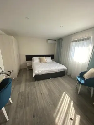 a bedroom with a white bed and a window at DMApartmani in Tuzla