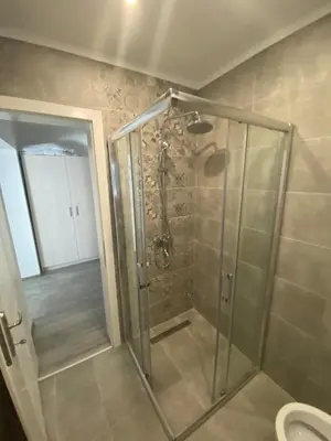a shower with a glass door in a bathroom at DMApartmani in Tuzla