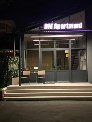 a restaurant with a sign on the front of it at night at DMApartmani in Tuzla