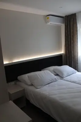 a bed with white sheets and pillows in a room at DM Sobe in Tuzla