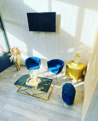 a living room with blue chairs and a tv at DM Sobe in Tuzla