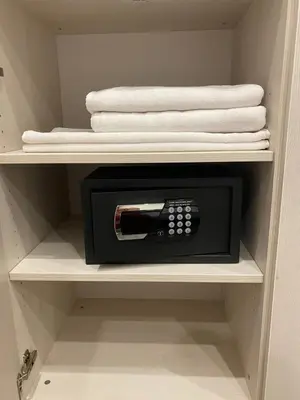 a microwave in a closet with some towels at DM Sobe in Tuzla