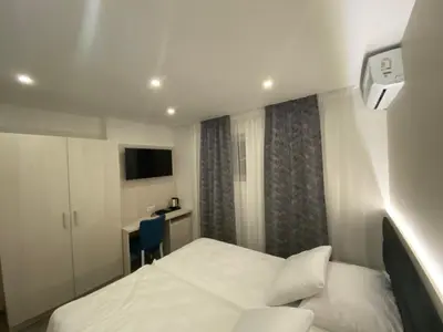 a hotel room with a bed and a desk at DM Sobe in Tuzla