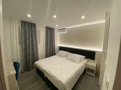 a bedroom with a white bed in a room at DM Sobe in Tuzla