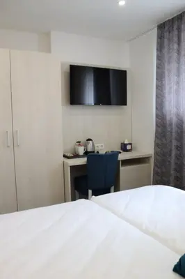 a bedroom with a bed and a desk with a chair at DM Sobe in Tuzla