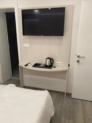 a room with a bed and a tv on the wall at DM Sobe in Tuzla
