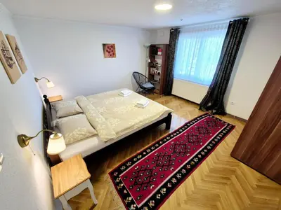 a small bedroom with a bed and a red rug at Apartman Alemina - mirna lokacija blizu centra, priroda i privatnost in Cazin