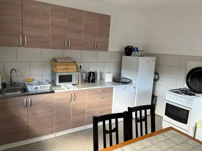 a kitchen with wooden cabinets and a white refrigerator at Althea Home & Wellness in Bihać