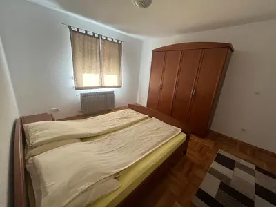 a bedroom with a bed and a cabinet and a window at Althea Home & Wellness in Bihać