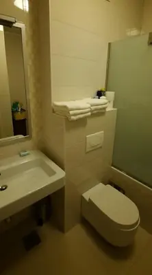 a bathroom with a toilet and a sink and a mirror at CENTAR 2 BANJA LUKA in Banja Luka