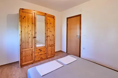 a bedroom with a bed and a wooden cabinet at Sutjeska in Modriča