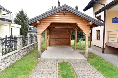 a wooden pavilion with a gate in front of a house at Sutjeska in Modriča