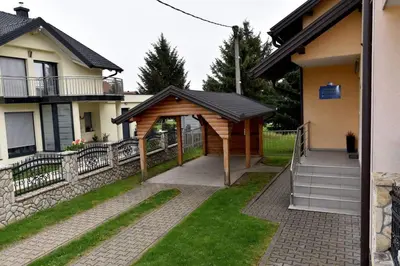 a wooden pavilion in a yard next to a house at Sutjeska in Modriča