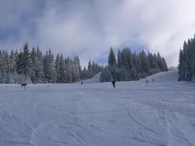 a group of people skiing down a snow covered slope at Vlašićki Konak in Vlasic
