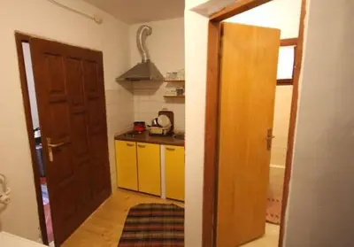 a kitchen with a door open to a kitchen with yellow cabinets at Vlašićki Konak in Vlasic
