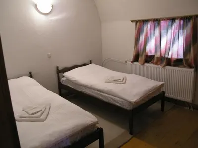 two twin beds in a small room with a window at Vlašićki Konak in Vlasic