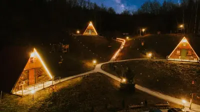a night view of a house with lights on it at Etno Village Dolina Sreće in Vitez