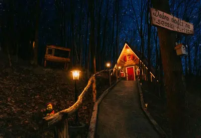 a wooden cabin in the woods at night at Etno Village Dolina Sreće in Vitez
