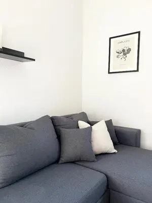 a gray couch with two pillows in a living room at Home Away From Home in Jajce