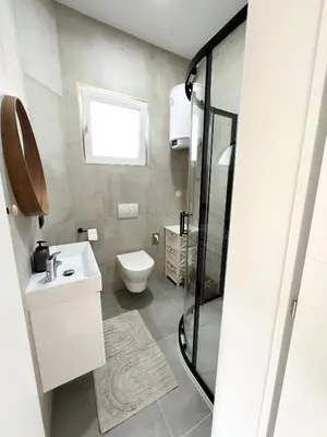 a bathroom with a toilet and a sink and a shower at Home Away From Home in Jajce