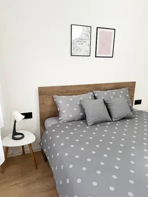 a bedroom with a bed with gray and white pillows at Home Away From Home in Jajce