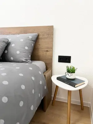 a bedroom with a bed and a table with a plant at Home Away From Home in Jajce