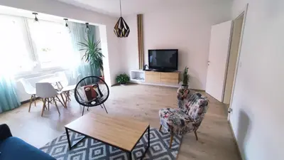 a living room with a table and chairs and a tv at Apartman Lena in Tuzla
