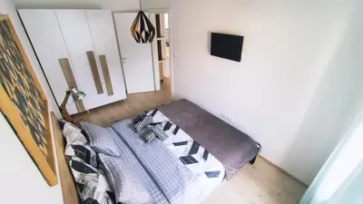 a bedroom with a bed with a pillow at Apartman Lena in Tuzla