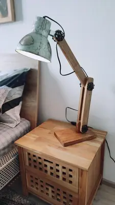 a lamp on a wooden table next to a bed at Apartman Lena in Tuzla