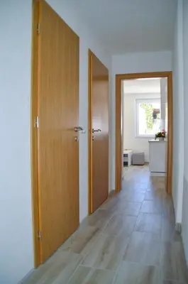 a hallway with two wooden doors and a floor at Apartman “Centar Jajce “ in Jajce