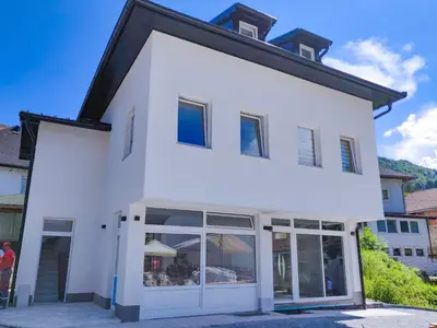 a white house with large windows and a roof at Apartman “Centar Jajce “ in Jajce