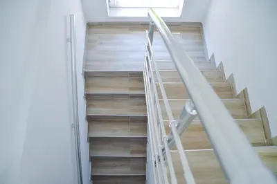 a staircase in a house with wooden floors and a window at Apartman “Centar Jajce “ in Jajce