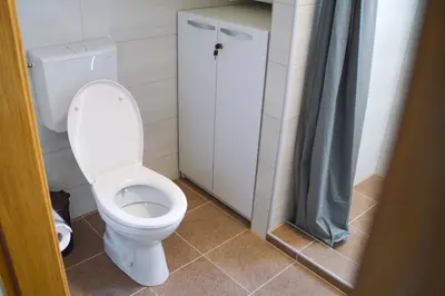 a bathroom with a toilet and a shower curtain at Apartman “Centar Jajce “ in Jajce